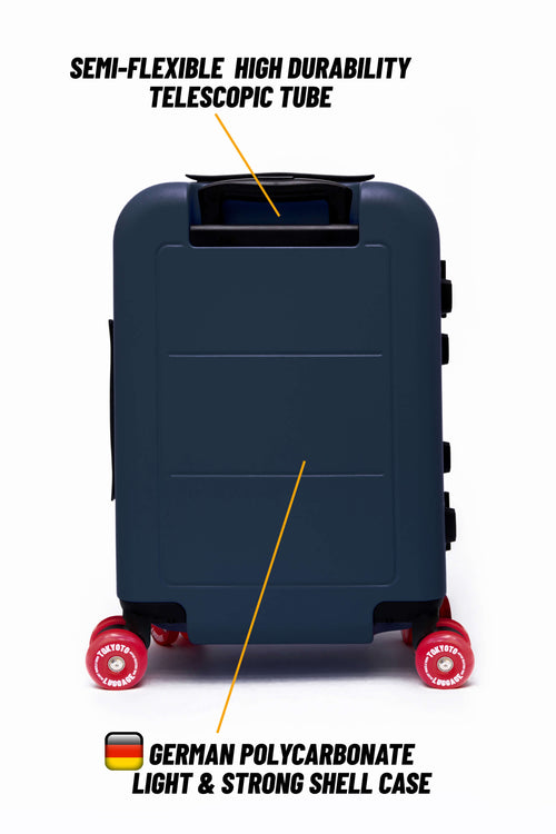A dark navy hard-shell suitcase shown from the back on a white background, with text callouts pointing to a semi-flexible high durability telescopic tube and German polycarbonate light and strong shell case. The suitcase has red wheels.