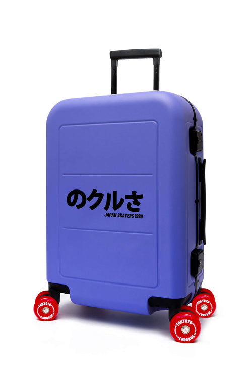 Ein lilafarbener Hartschalenkoffer auf Rollen mit roten Rädern und schwarzen Griffen, auf dessen Vorderseite japanischer Text aufgedruckt ist, vor einem schlichten weißen Hintergrund.