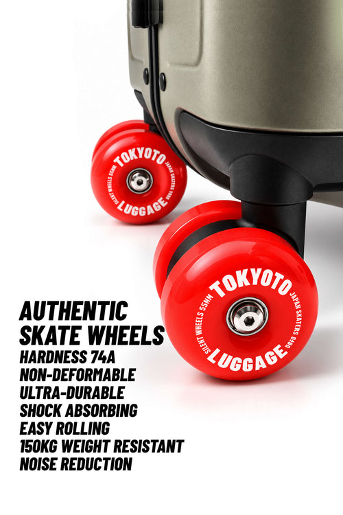 Primo piano dell’area delle ruote di una valigia, che mostra due rotelle da skate Tokyo Luggage di un rosso brillante con il marchio stampato in bianco, accanto a un testo promozionale che descrive le caratteristiche delle ruote.