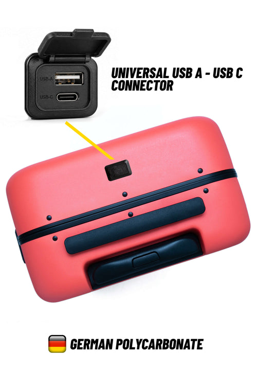 A coral pink hard-shell suitcase shown from the back, featuring a small black square cutout near the top that highlights a universal USB A to USB C connector. The image includes text overlays reading 'UNIVERSAL USB A - USB C CONNECTOR' and 'GERMAN POLYCARBONATE' with a German flag icon.