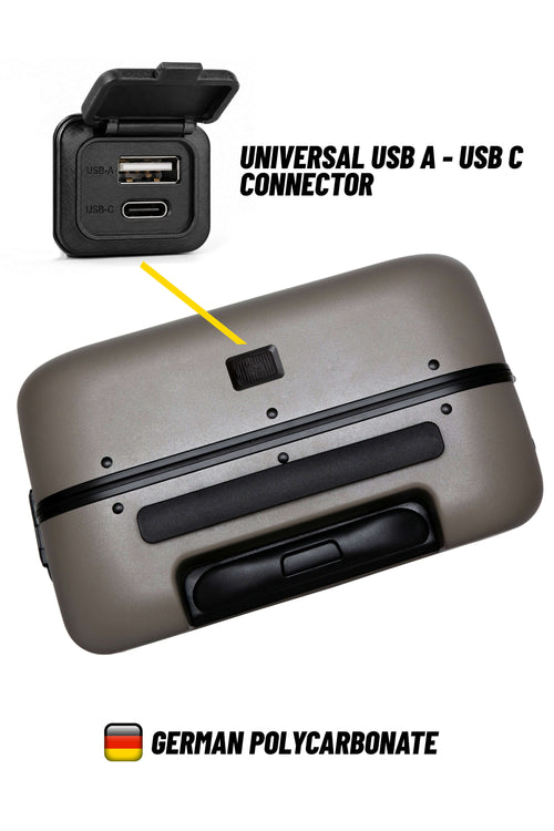 A gray hard-shell suitcase shown from the bottom, with a small black square cutout on the lid. An inset at the top shows a universal USB A - USB C connector, with a yellow arrow pointing to the cutout on the suitcase.