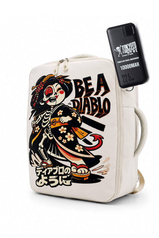 Uno zaino in tela color bianco sporco con un’illustrazione grafica di uno scheletro in kimono, la scritta «BE A DIABLO» e testo giapponese. Alla cerniera laterale è agganciata una custodia nera per telefono con la scritta «TRICK OR TREAT».