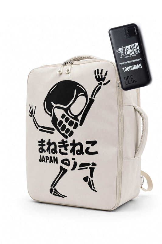 Zaino in tela color bianco sporco con una grafica nera raffigurante uno scheletro danzante, del testo giapponese e la scritta «JAPAN» stampata sotto. Sul lato della borsa è applicata una custodia nera per telefono con la scritta «TRICK OR TREAT» e il marchio «1000MAH».